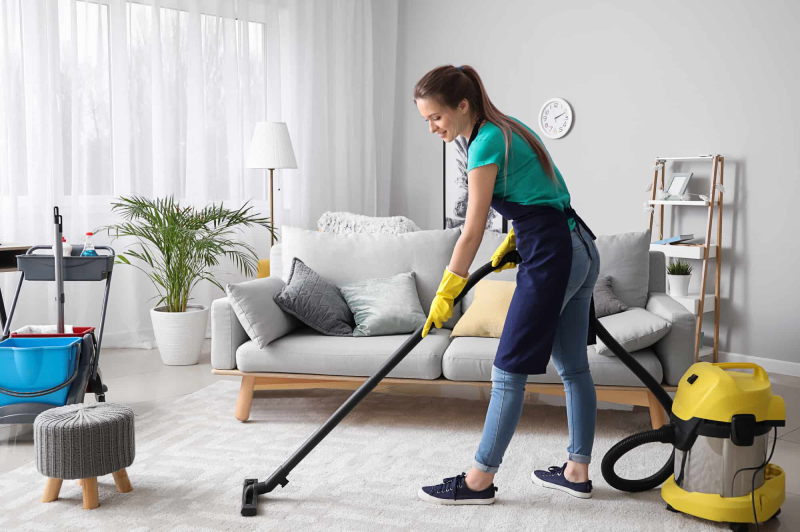 woman vacuuming carpet in living room